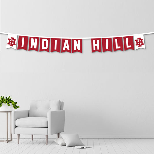 Red and white 'Indian Hill' banner hanging above a white armchair in a minimalistic room.